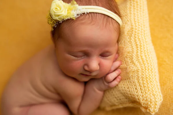 Aranyos baba újszülött szunyókál párnán egy sárga takarón — Stock Fotó