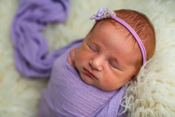 Durmiendo, niña recién nacida de nueve días envuelta en una envoltura violeta —  Fotos de Stock