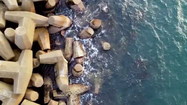 Luchtfoto van betonnen zee versteviging textuur. Breakwaters. Zee stad strand met golfbrekers. Blauwe zee. Drone — Stockvideo