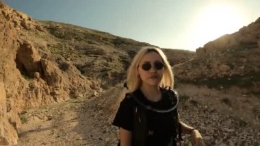 Genç sarışın, dağlarda yürüyüş yaparken fotoğraflarını çekiyor. Seyahat blogu ve anıları var.