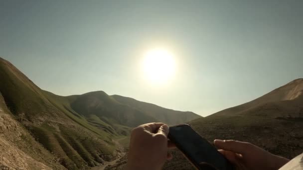 Vue à la première personne, l'homme prend une photo d'une montagne sur smartphone. Concept, tourisme. Vue POV — Video