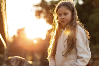 Parkta batan güneşin altında, beyaz tenli sarışın bir kız. Yüksek kalite fotoğraf