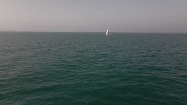 Yacht med reflektion segling på öppet hav antenn. Ingen natur sjölandskap med segelbåt cruising vid havsviken. Bergslandskapet på Arran Island, Skottland. Filmisk sommarsemester landskap — Stockvideo