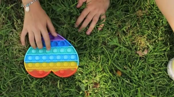 Bunte Antistress-Sensor-Spielzeug Fidget Push Pop es in Kinderhänden — Stockvideo