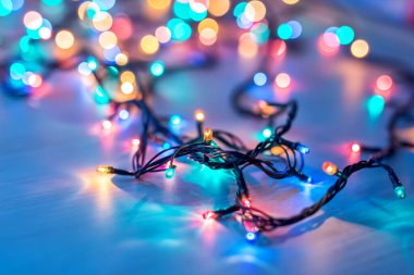 Koyu mavi arka planda fotokopi alanı olan Noel ışıkları. Dekoratif çelenk