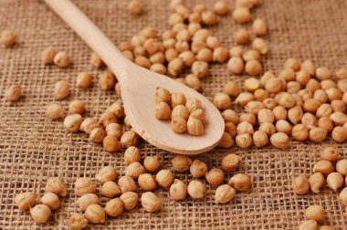 Üzerinde kahverengi zemin üzerine tahta kaşık nohut