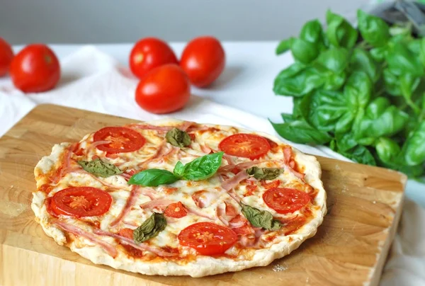 Pizza se šunkou, rajčaty a bazalkou — Stock fotografie