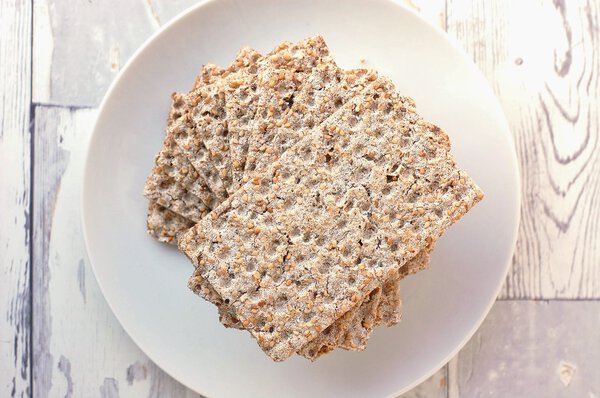 Dry bread on the plate on the wooden background