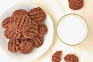 Bir bardak süt ile plaka üzerinde kakao bisküvi