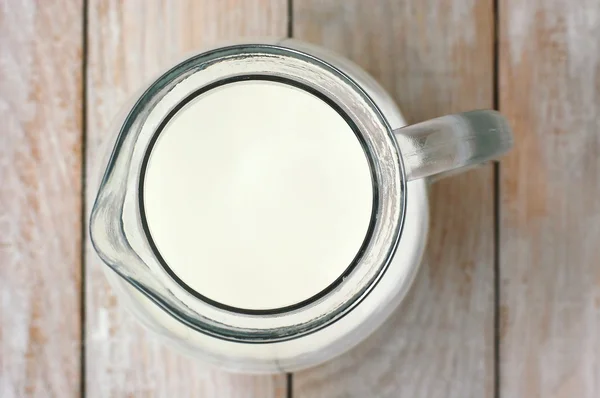 Weiße Milch die Kanne auf dem hölzernen Hintergrund — Stockfoto