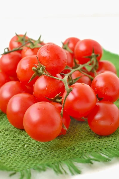 Beyaz zemin üzerine yeşil topçu kumaş üzerine domates — Stok fotoğraf
