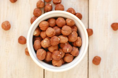 Ahşap arka plan üzerinde kase fındık