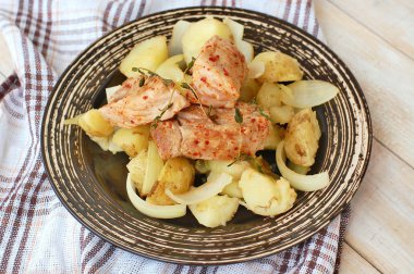 Domuz eti bonfile kırmızı biber biber ve kavrulmuş patates ve soğan ile karanlık plaka üzerinde taze kekik ile kavrulmuş