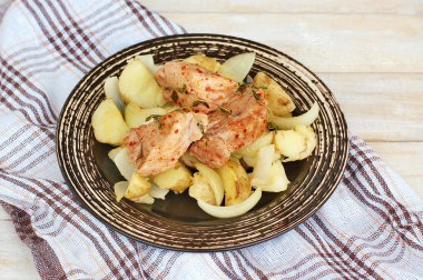 Domuz eti bonfile kırmızı biber biber ve kavrulmuş patates ve soğan ile karanlık plaka üzerinde taze kekik ile kavrulmuş