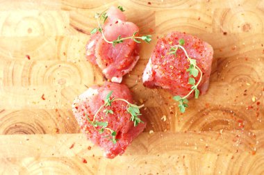 Çiğ domuz eti bonfile kırmızı biber biber ve pişirmeye hazır ahşap üzerine taze kekik ile