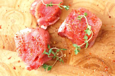 Çiğ domuz eti bonfile kırmızı biber biber ve pişirmeye hazır ahşap üzerine taze kekik ile