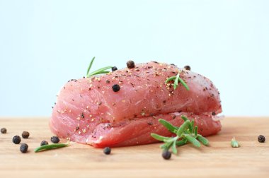 Çiğ domuz eti bonfile kara biber ve biberiye pişirmeye hazır ahşap üzerine