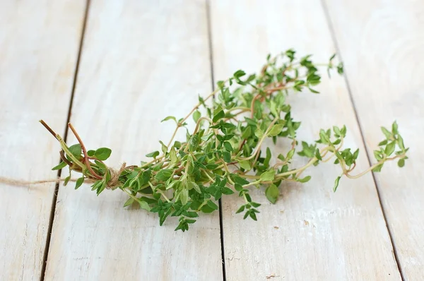 Frischer grüner Kräuterthymian auf weißem Holzhintergrund — Stockfoto