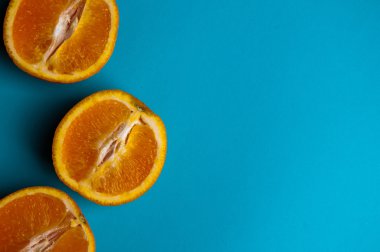 Mavi arka plan üzerinde yukarıdan portakal kesilmiş