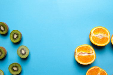 Kivi ve turuncu meyve mavi zemin üzerine.