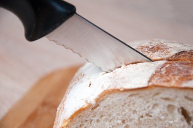 Kesme tahtası, ekmek ve tahta bir masanın üzerinde yatan bir bıçak