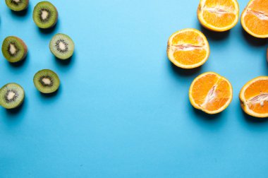 Kivi ve turuncu meyve mavi zemin üzerine.