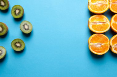 Kivi ve turuncu meyve mavi zemin üzerine.