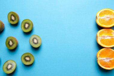 Kivi ve turuncu meyve mavi zemin üzerine.