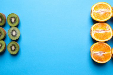 Kivi ve turuncu meyve mavi zemin üzerine.