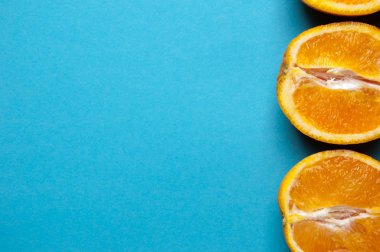 Mavi arka plan üzerinde yukarıdan portakal kesilmiş