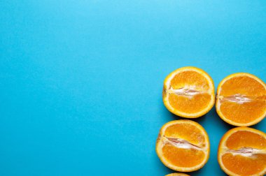 Mavi arka plan üzerinde yukarıdan portakal kesilmiş