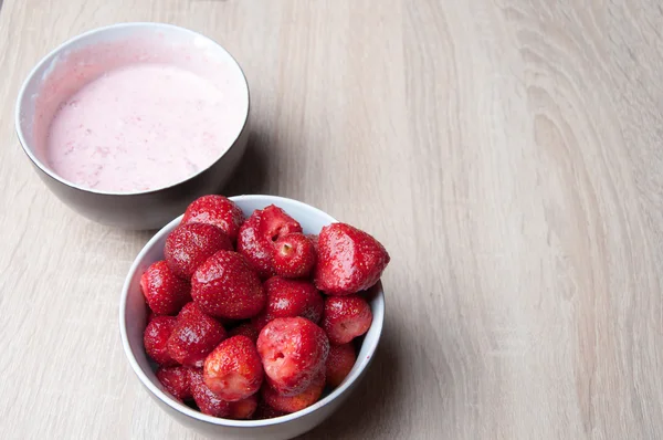 Fresas y fresas con crema en cuenco sobre mesa de madera —  Fotos de Stock