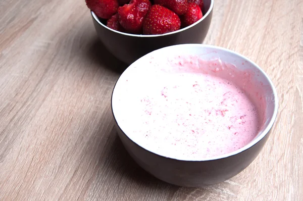 Fresas y fresas con crema en cuenco sobre mesa de madera —  Fotos de Stock