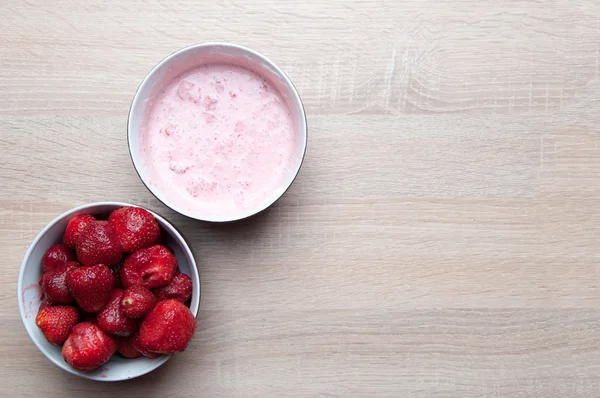 Fresas y fresas con crema en cuenco sobre mesa de madera —  Fotos de Stock