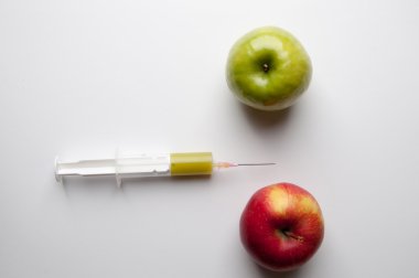 Şırınga ile yeşil ve Kırmızı elma. GDO