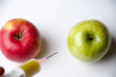 Şırınga ile yeşil ve Kırmızı elma. GDO