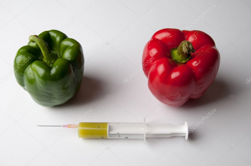 Green and reed pepper with syringe. GMO
