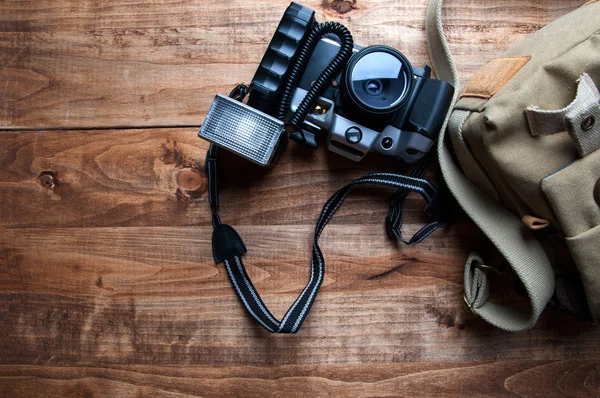 Eski fotoğraf makinesi ve çanta, ahşap arka plan — Stok fotoğraf