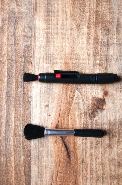 Ручка и кисть для очистки камеры и объектива, изолированные на дереве — стоковое фото