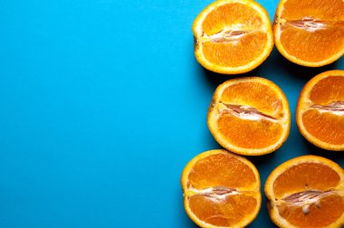 Mavi arka plan üzerinde yukarıdan portakal kesilmiş