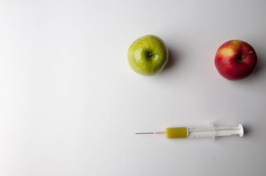 Şırınga ile yeşil ve Kırmızı elma. GDO