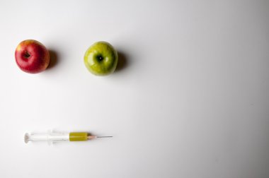 Şırınga ile yeşil ve Kırmızı elma. GDO