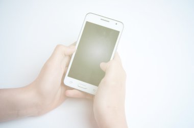 Kız beyaz bir akıllı telefon tutarak. Beyaz arka plan