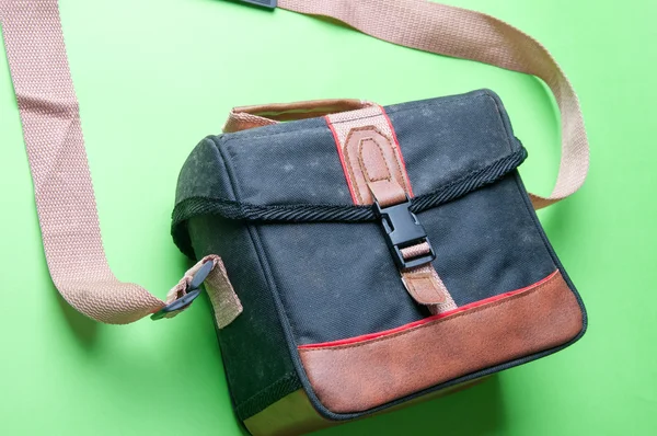 Yeşil bir arka plan üzerinde eski kamera çantası — Stok fotoğraf
