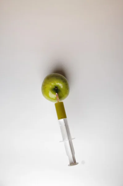 GMO яблуко з шприцом на білому — стокове фото