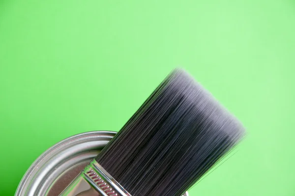 Pincel y pintura sobre un fondo verde — Foto de Stock