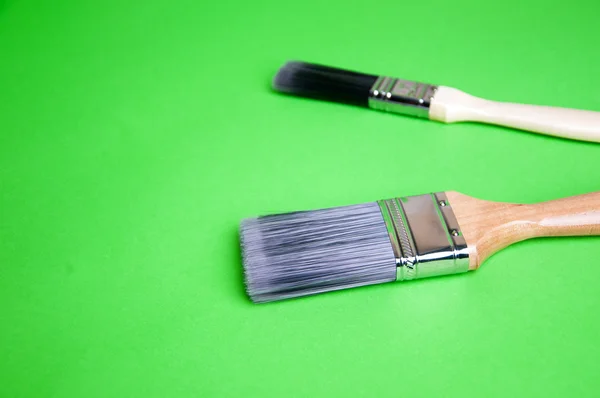 Pinsel und Farbe auf grünem Hintergrund — Stockfoto