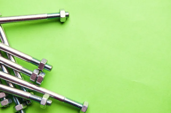 La imagen de tornillos y tuercas sobre un fondo verde — Foto de Stock