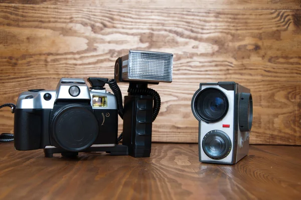 Eski fotoğraf makinesi ve video kamera ahşap bir masa üzerinde — Stok fotoğraf