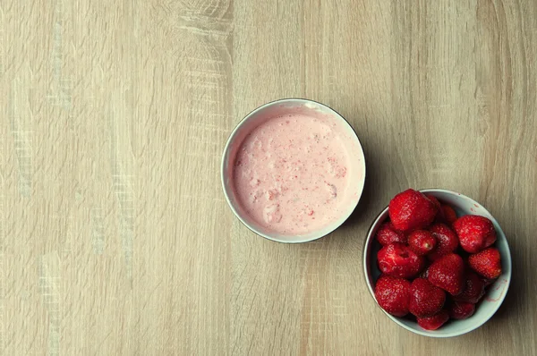 Fresas y fresas con crema en cuenco sobre mesa de madera —  Fotos de Stock